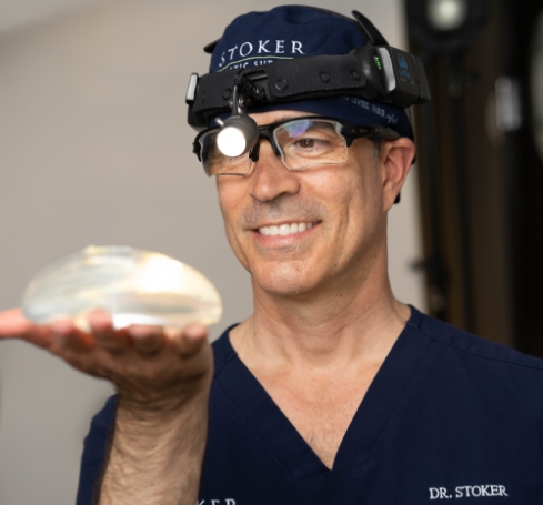 Dr. Stoker holding a breast implant